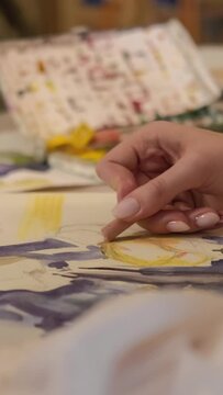 Vertical video. Painting art. Creative process. Talent imagination. Female artist hand creating yellow blue abstract artwork with wax crayon watercolor on canvas.
