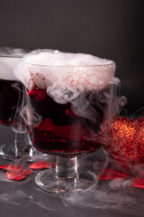 Valentine's day cocktail with dry ice on dark background