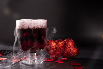 Valentine's day cocktail with dry ice on dark background