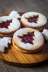 Linzer cookies with christmas tree shape on a wooden table