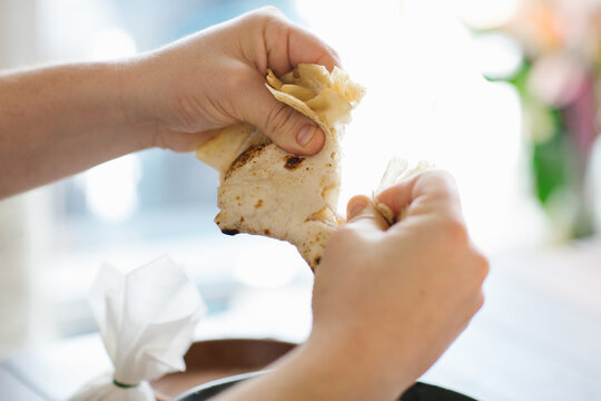 Close up shot of hands tearing a pita bread