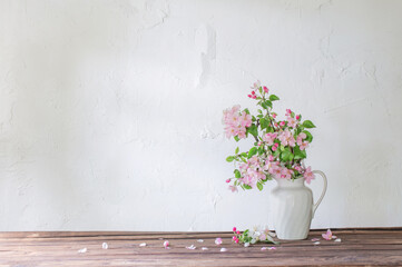 apple flowers in white jug on background grunge wall