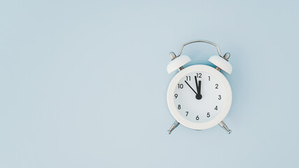 top view of white analog alarm clock on grunge blue background including copy space