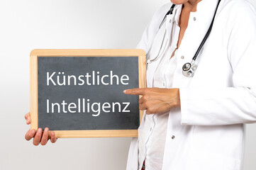 Ärztin zeigt auf eine Tafel auf der Künstliche Intelligenz steht