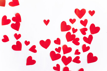 Flat lay Valentine's Day background with red paper cut out hearts on white background. Top view. Holiday background.