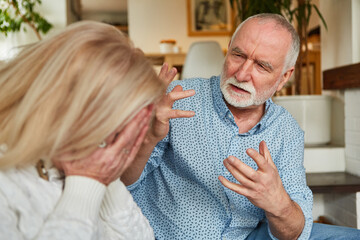 Old man quarreling with his crying wife at home - obrazy, fototapety, plakaty