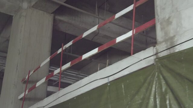 Striped protective fence tapes for builders safety on floor of future public center building. Safety at construction site