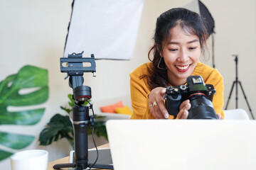 Lifestyle Asia young women photographer and freelance holding a dslr camera in  home office. ...