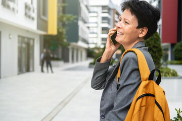 Happy woman with short haircut talks on phone