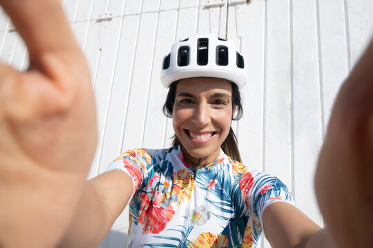 Happy cyclist taking selfie in front of wall - Powered by Adobe