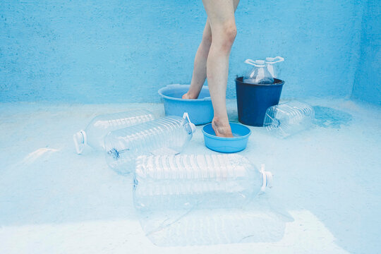 Woman standing inside empty buckets in swimming pool
