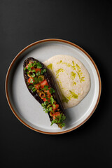 Roasted eggplant stuffed with fresh tomatoes and hazelnuts. Delicious vegetarian food