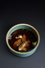 Soup with mushrooms and Ptitim isolated over plain dark background