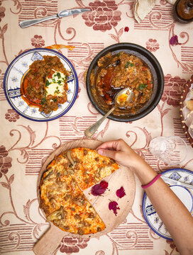 High Angle View of Traditional Morocco food and hand holding the pizza