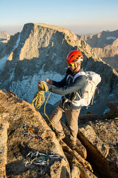 Man coiling rope on summit of Mount Mendel