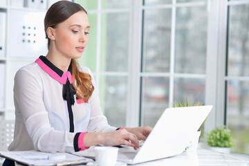 young woman working with laptop in modern office