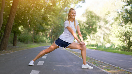 Woman runner stretching legs before exercising summer park  morning