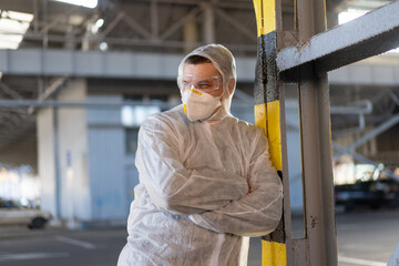 COVID-19 coronavirus doctor standing hospital parking dressed white protective overalls hazmat suit.