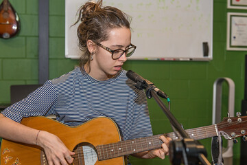 Young lady playing guitar and singing