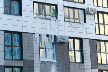 icicle on the windows and glass of a modern house due to an accident in the heating system.