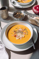 Family meal. Pumpkin cream soup with seeds and bacon. Vegetable seasonal soup.