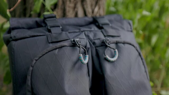 close up macro shot of black zipper pull and fabric of modern backpack with buckles