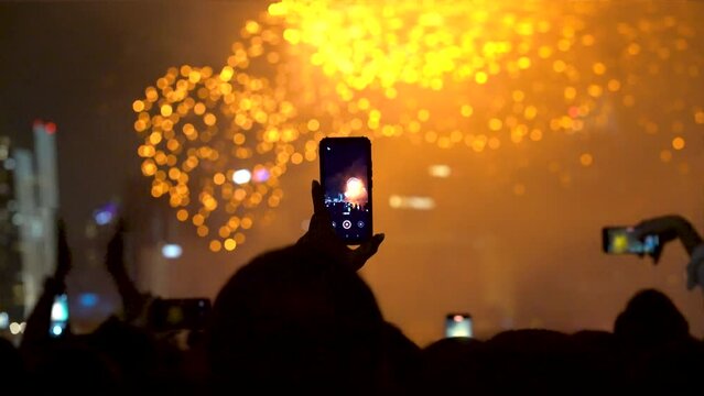 People taking photos of new year fireworks. Celebration at Marina Bay Singapore 2023 countdown