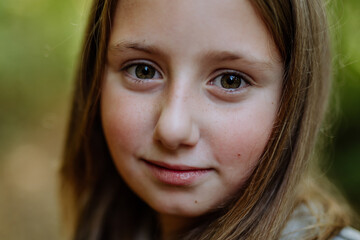 Fototapeta premium Portrait of smiling girl in a forest.