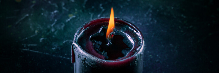 Burning candles on a dark background, mysterious ritual panorama