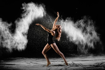 Plakat Young beautiful woman with spread flour on the air on a black background