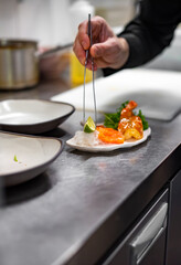 chef cooking slice salmon fish and shrimp with salad on kitchen