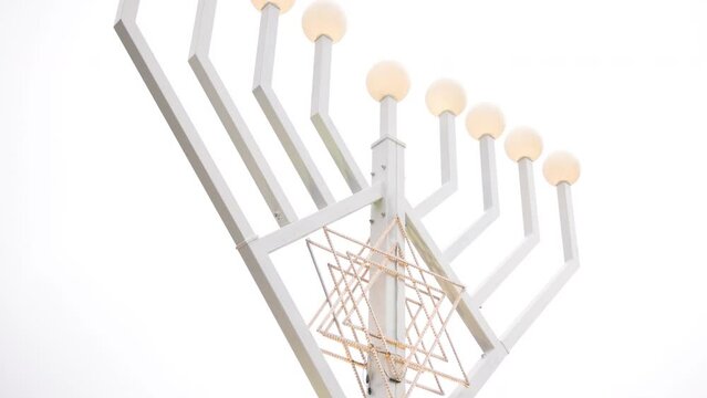 German Berlin street lamp with glitter lights on menorah is a traditional symbol of Jewish Hanukkah Holiday of Light, a Hanukkah background with candles and candelabra on menorah.