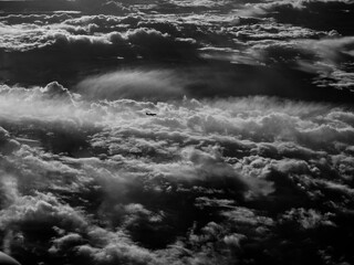 Ein Flugzeug fliegt über eine Wolkenlandschaft hinweg. 