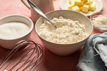 Close up flour in bowl with baking tools and ingredients. Sugar, milk, butter, eggs.