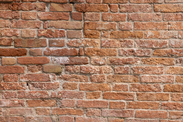 Old red brick clay wall with on a sunny day. Clay brick walls of Italy. italian architecture and heritage