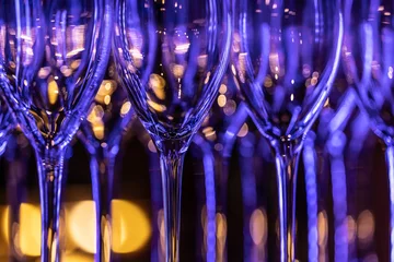 Clean wine glasses in the night bar glowing with neon colors