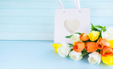 Bouquet of tulips and pink gift bag. Image with selective focus