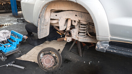 Old and rusty car's suspension parts.
Change the old disc brake and caliper on car.