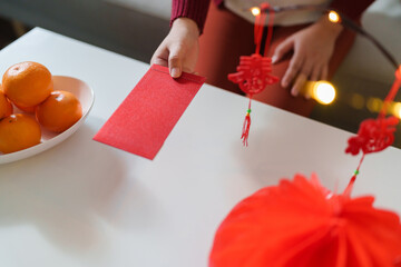 Asian Woman giving red envelope for Lunar New Year celebrations. Hand hold red packet thankful...