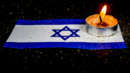 Israeli flag and candles burning above it, Holocaust memory day