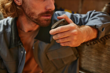 Close up of bearded sailor talking by radio on boat, copy space