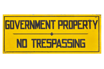 Vintage yellow American sign with the text "Government property no trespassing"