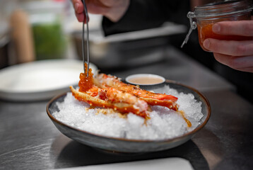 chef cooking crab legs with caviar on kitchen