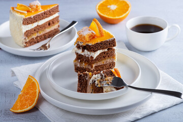 Cake, orange and coffee on a light wooden table
