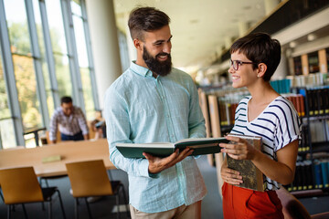 Happy group of students studying and working together in a college library