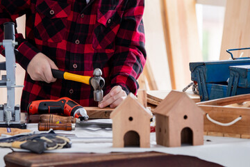 Lovely Asian carpenter boy acting present his work in front of DIY woodworking table carpentry shop...