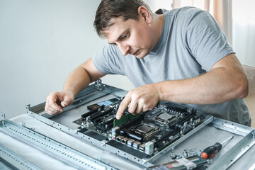 Man engineer,collector.Independent self computer assembly. Mounting in sockets processor,random access memory RAM,motherboard,fan. Assembly of home crypto farm.Generating tokens,cryptocurrency mining