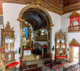 Fototapeta na wymiar Interior of a antique baroque church in Salvador, Bahia, richly decorated with gold-plated walls and altar