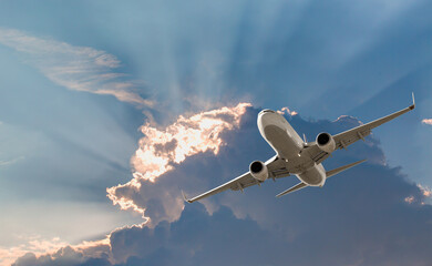 Airplane flying over tropical sea at sunset