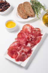 Italian slices of coppa, capocollo, capicollo, bresaola or cured ham with rosemary. Raw food.  